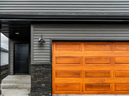 Premium gray garage doors on brick suburban home
