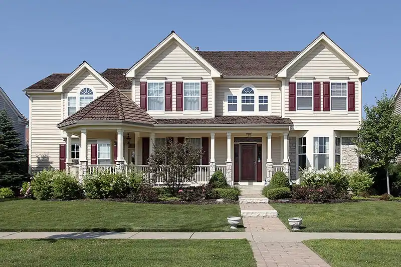 Traditional two story home with decorative shutters and white siding